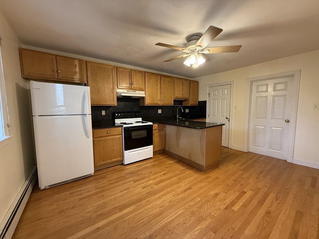 314 Webster Street, Unit B Needham, MA 02494 - Photo 5 of 14 a kitchen with kitchen island a sink stainless steel appliances and cabinets