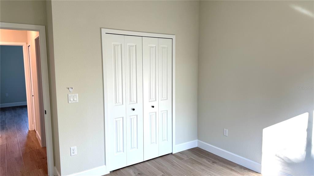 4884 Kisla Rd Port North Port, FL 34288 - Photo 11 of 19 an empty room with wooden floor and windows