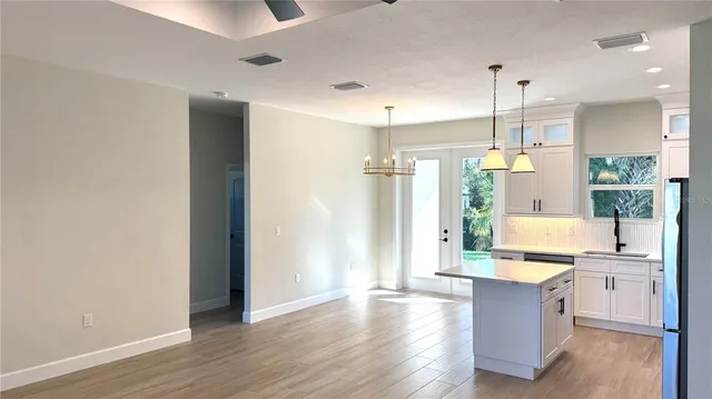 a large kitchen with a window and stainless steel appliances