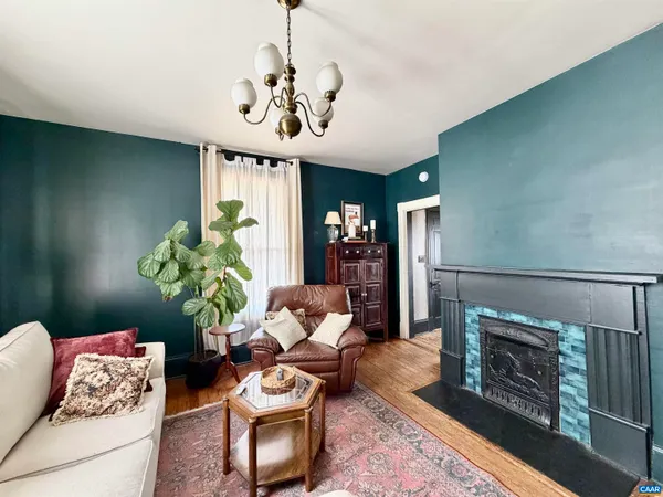 a living room with furniture a chandelier and a fireplace