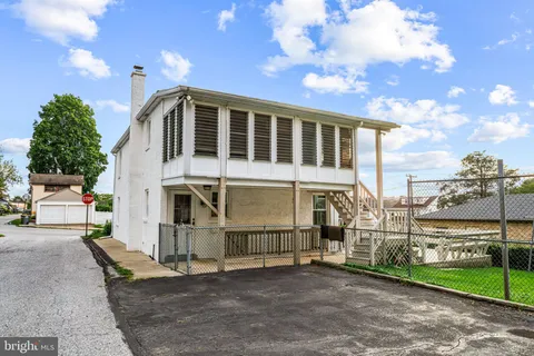a view of a house with a big yard and a large tree