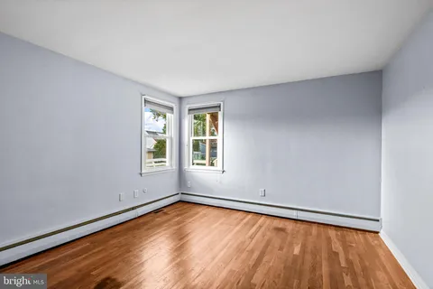 a view of empty room with wooden floor