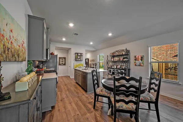 a kitchen with stainless steel appliances granite countertop a sink a stove and a wooden floors