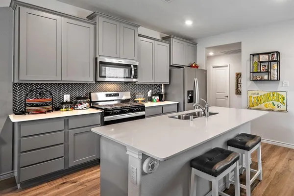 a kitchen with a sink a stove a refrigerator and cabinets