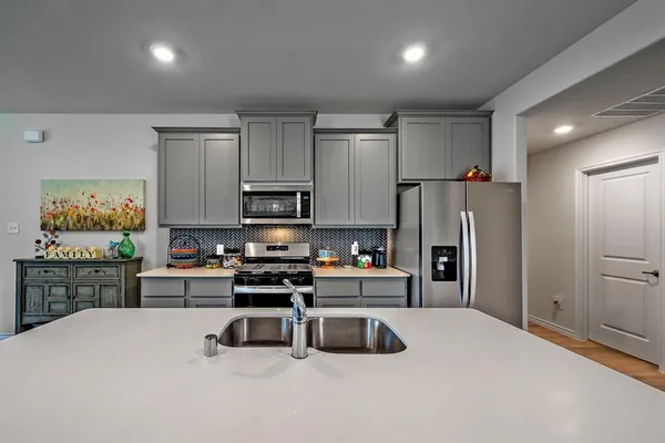 a kitchen with stainless steel appliances granite countertop a refrigerator sink and stove