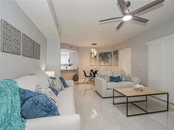 a living room with furniture and a ceiling fan