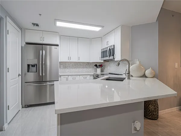 a kitchen with a sink a refrigerator and a stove top oven