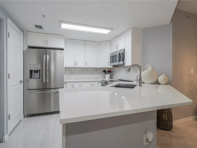 a kitchen with a sink a refrigerator and a stove top oven