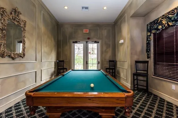 a view of a tennis ground with large trees