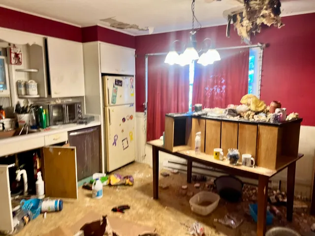a room with chandelier furniture and view of kitchen