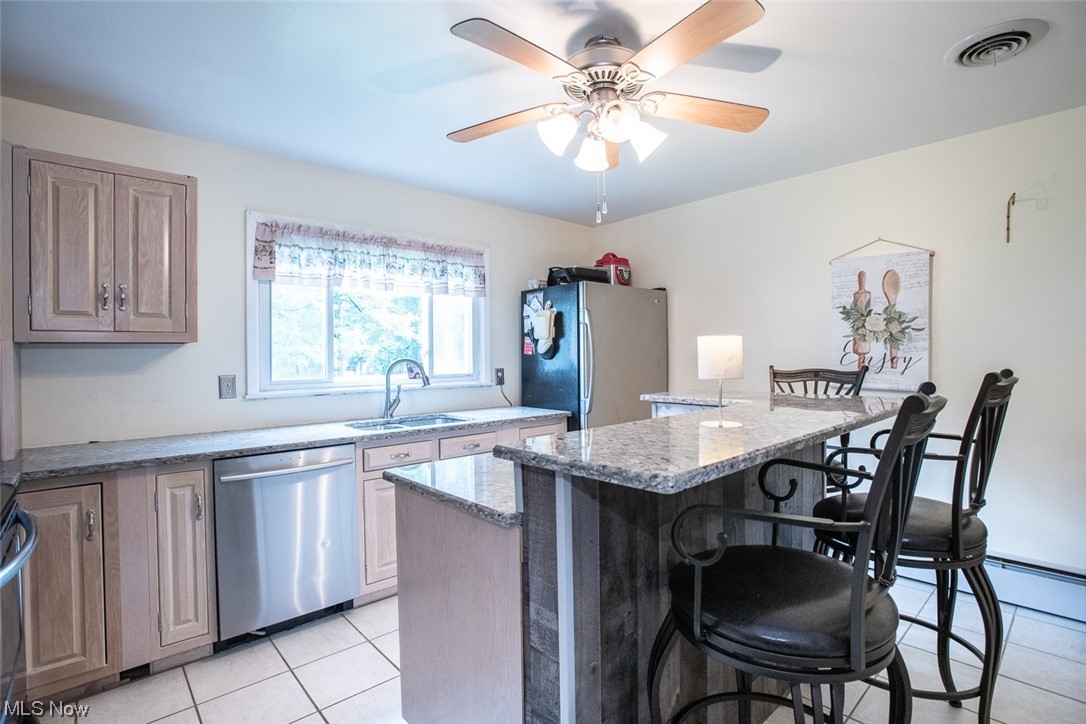 20873 Drake Road Strongsville, OH 44149 - Photo 14 of 25 Kitchen featuring light countertops, light tile floors, a center island, ceiling fan, and stainless steel appliances