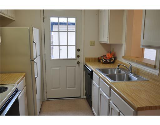 6702 Everhart Road, Unit 104W Corpus Christi, TX 78413 - Photo 5 of 10 a kitchen with a sink a refrigerator and cabinets