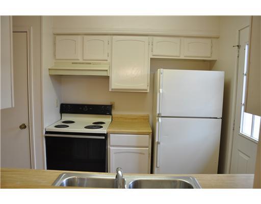 6702 Everhart Road, Unit 104W Corpus Christi, TX 78413 - Photo 6 of 10 a kitchen with a refrigerator and a stove