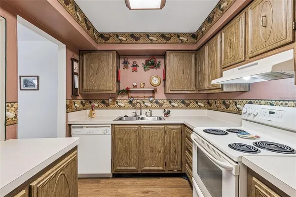 a kitchen with a sink a stove cabinets and a dining table