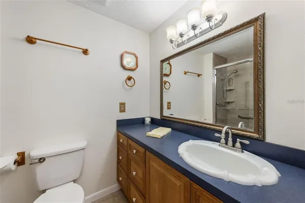 a bathroom with a granite countertop sink mirror and toilet