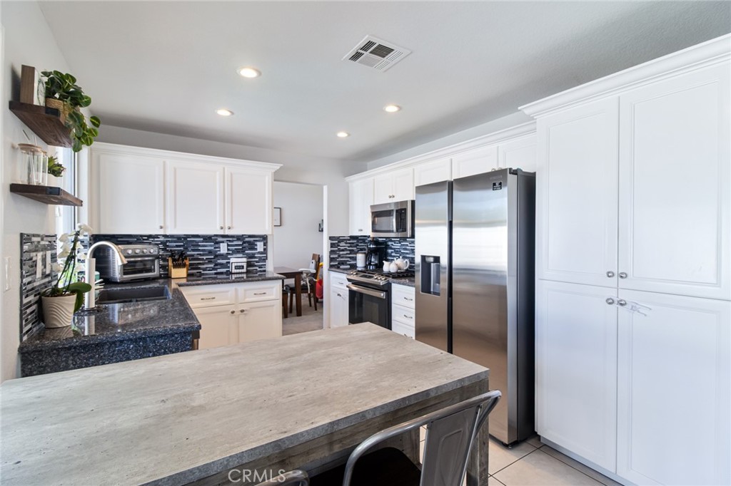 32182 Cala Torrente Temecula, CA 92592 - Photo 12 of 35 a kitchen with stainless steel appliances granite countertop a refrigerator sink stove microwave and cabinets
