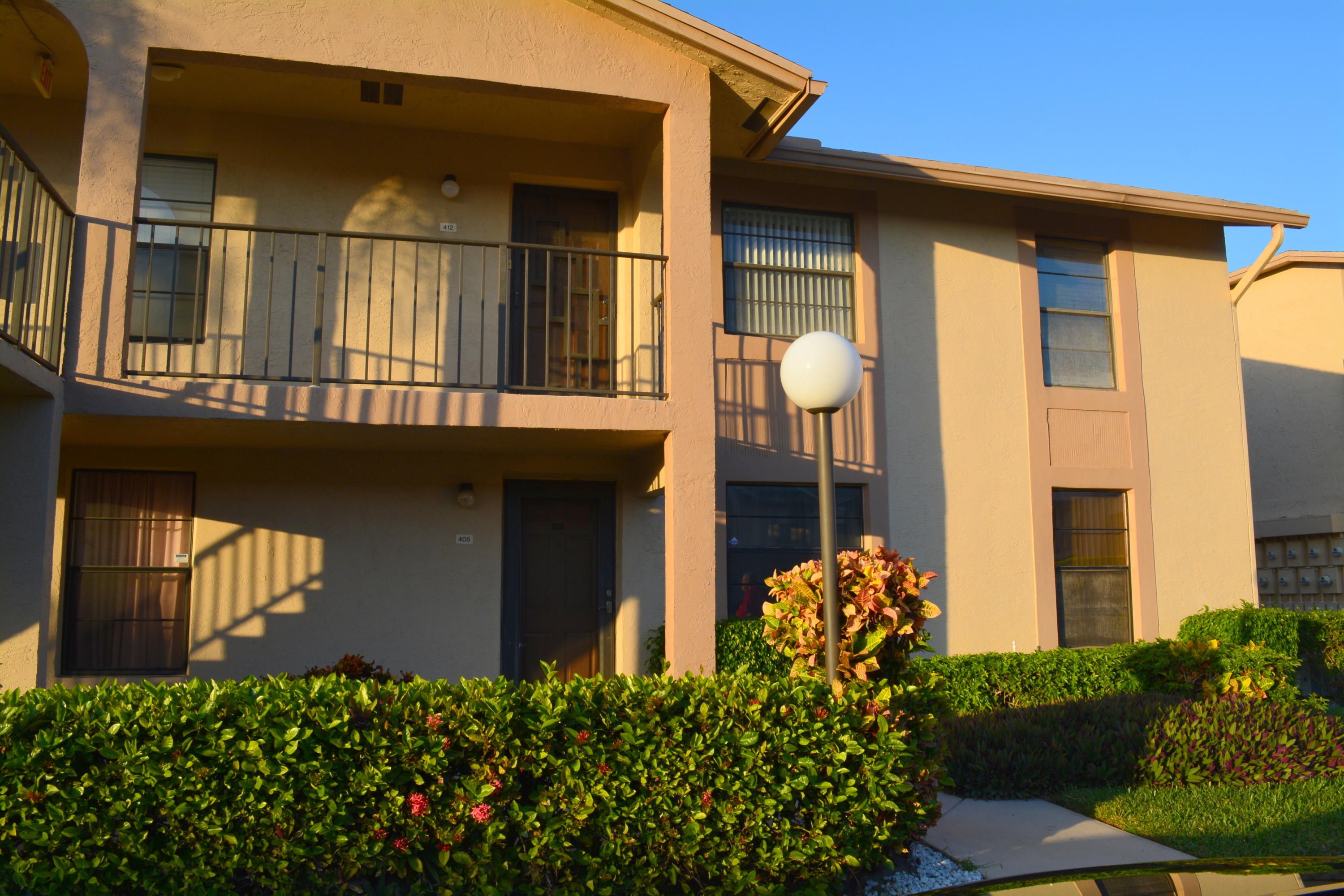9480 Boca Cove Circle, Unit 405 Boca Raton, FL 33428 - Photo 1 of 12 a front view of a house with a yard