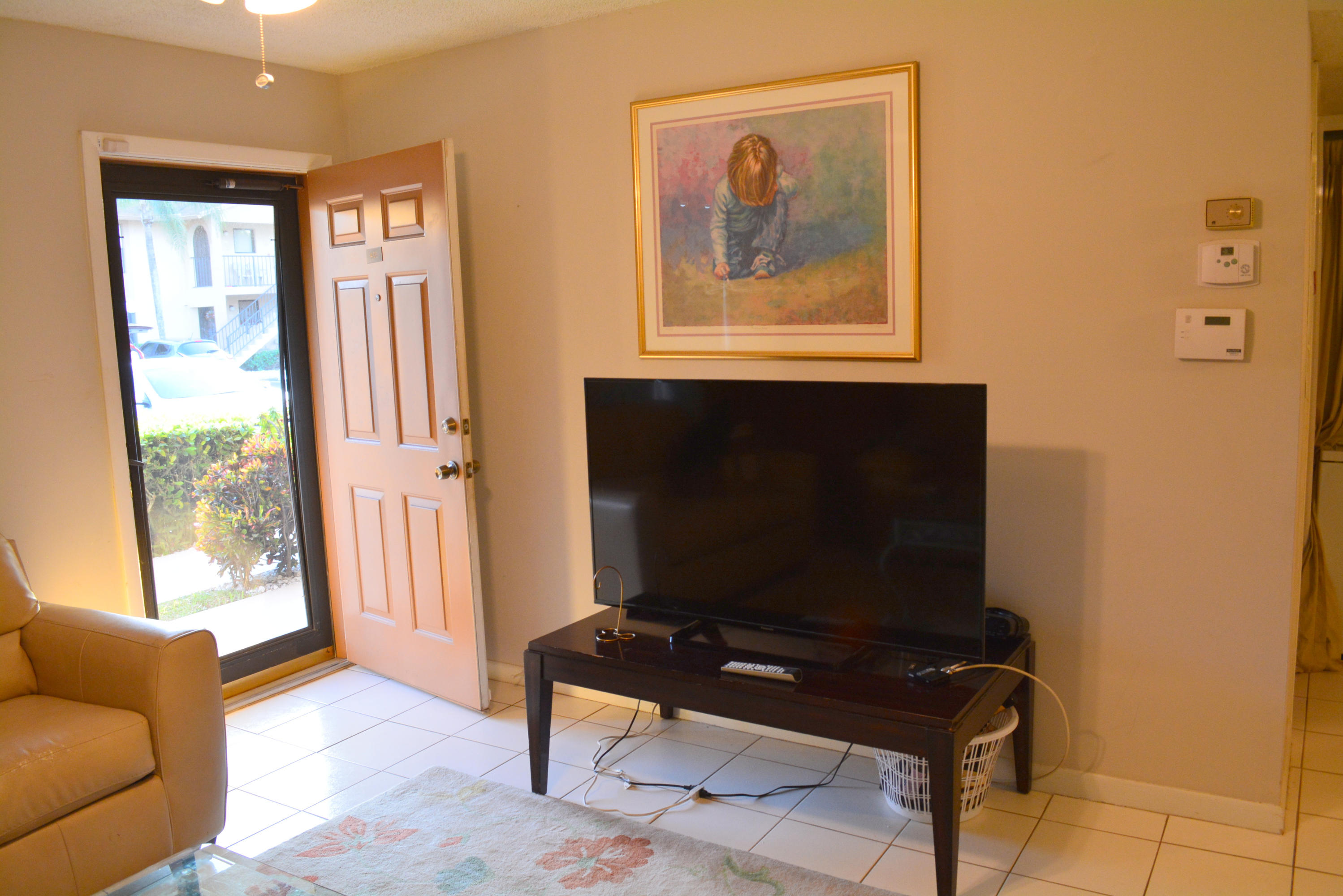 9480 Boca Cove Circle, Unit 405 Boca Raton, FL 33428 - Photo 4 of 12 a living room with furniture and a flat screen tv