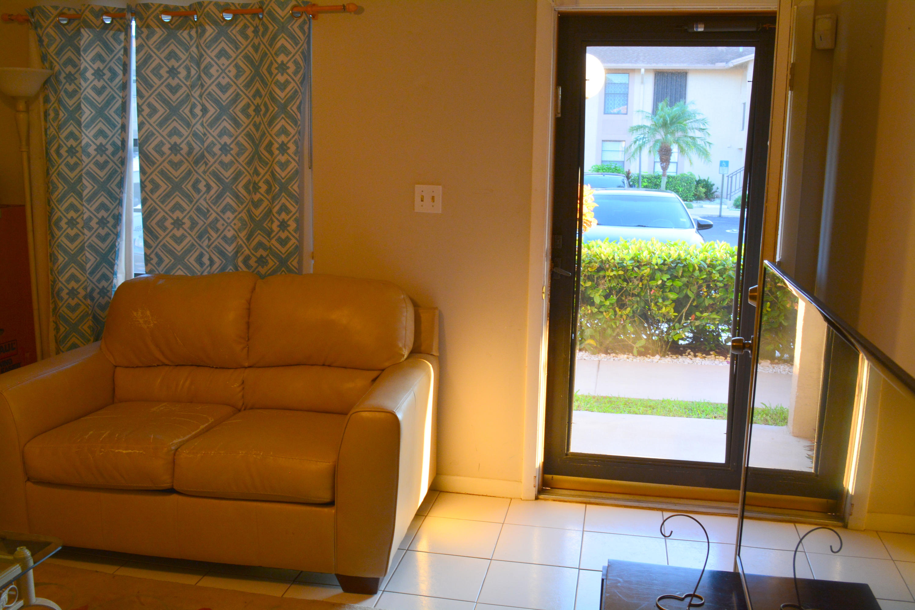9480 Boca Cove Circle, Unit 405 Boca Raton, FL 33428 - Photo 6 of 12 a living room with a couch and a next to a window