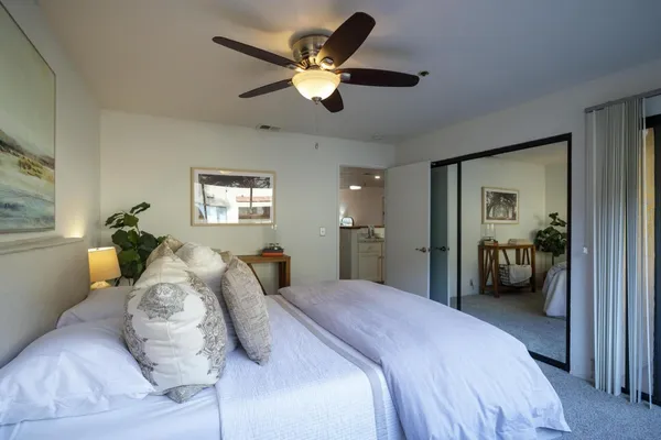 a bedroom with a large bed and a chandelier