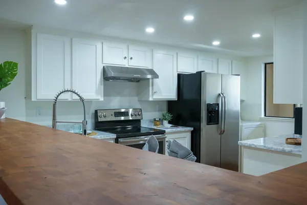 a kitchen with stainless steel appliances granite countertop a refrigerator stove and sink
