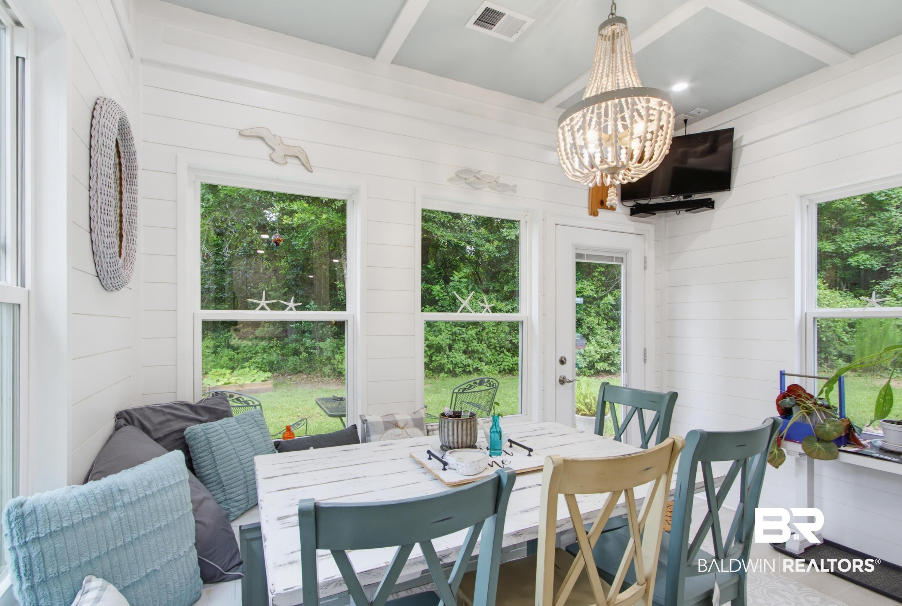 7472 Coopers Landing Road Foley, AL 36535 - Photo 14 of 40 Bright dining space featuring shiplap walls, a coffered ceiling, and a beaded chandelier