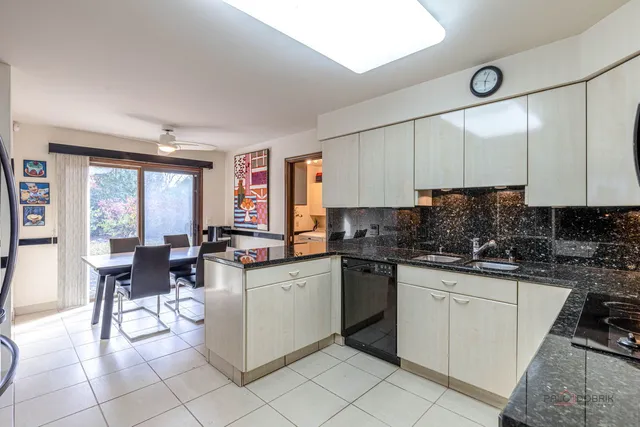 a kitchen with a sink dining table and chairs