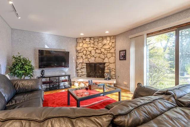 a living room with furniture a flat screen tv and a large window