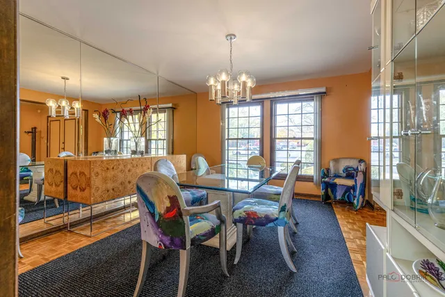 a dining room with furniture a chandelier and wooden floor