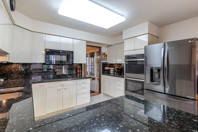 a kitchen with stainless steel appliances a refrigerator a stove a sink a counter top space and cabinets