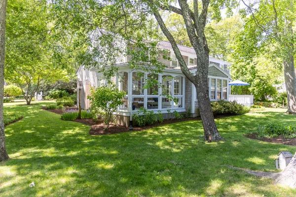 a view of a house with a big yard and large trees