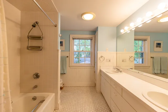 a bathroom with a tub a sink and a large mirror
