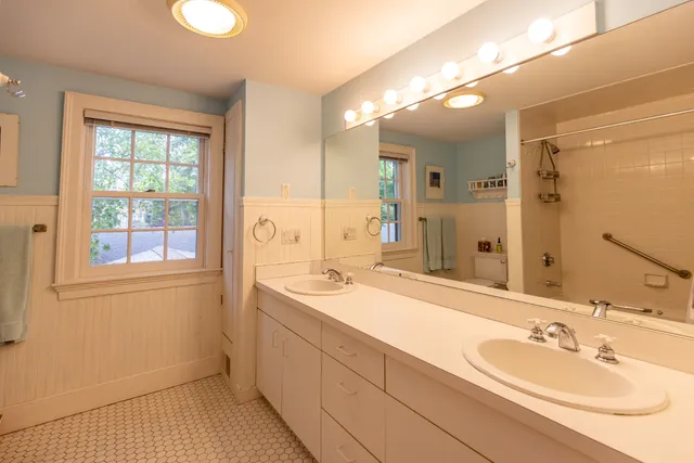 a bathroom with a sink double vanity granite and a mirror