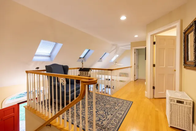 a view of a hallway with wooden floor and staircase