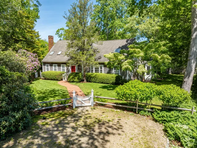 a view of house with a yard and sitting area
