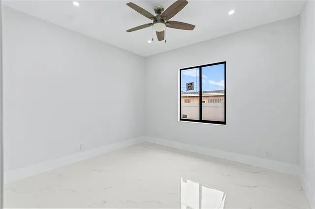 an empty room with window and ceiling fan