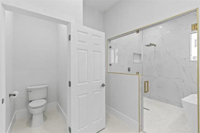 a bathroom with a shower a toilet and a sink