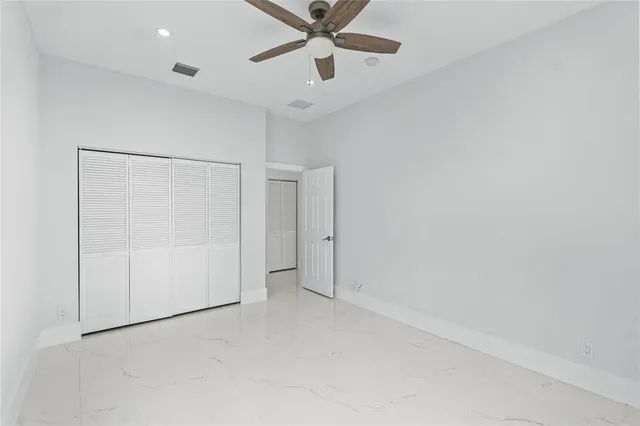 an empty room with closet and windows