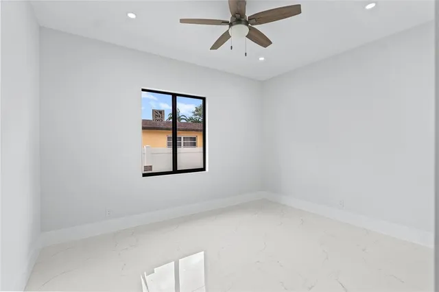 an empty room with windows and fan