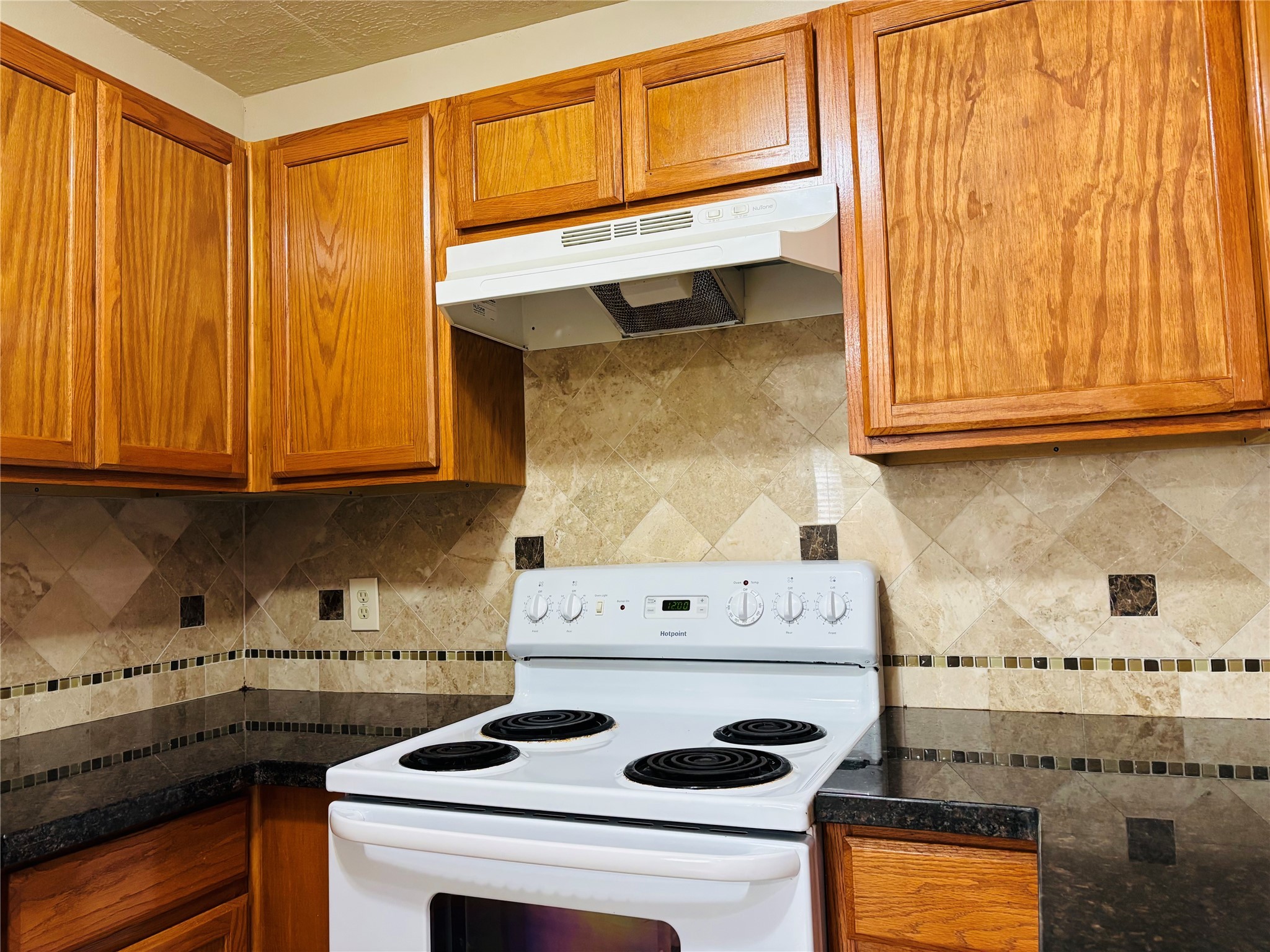 12409 Sharpview Drive, Unit 2409 Houston, TX 77072 - Photo 4 of 21 a kitchen with a stove and a white cabinet