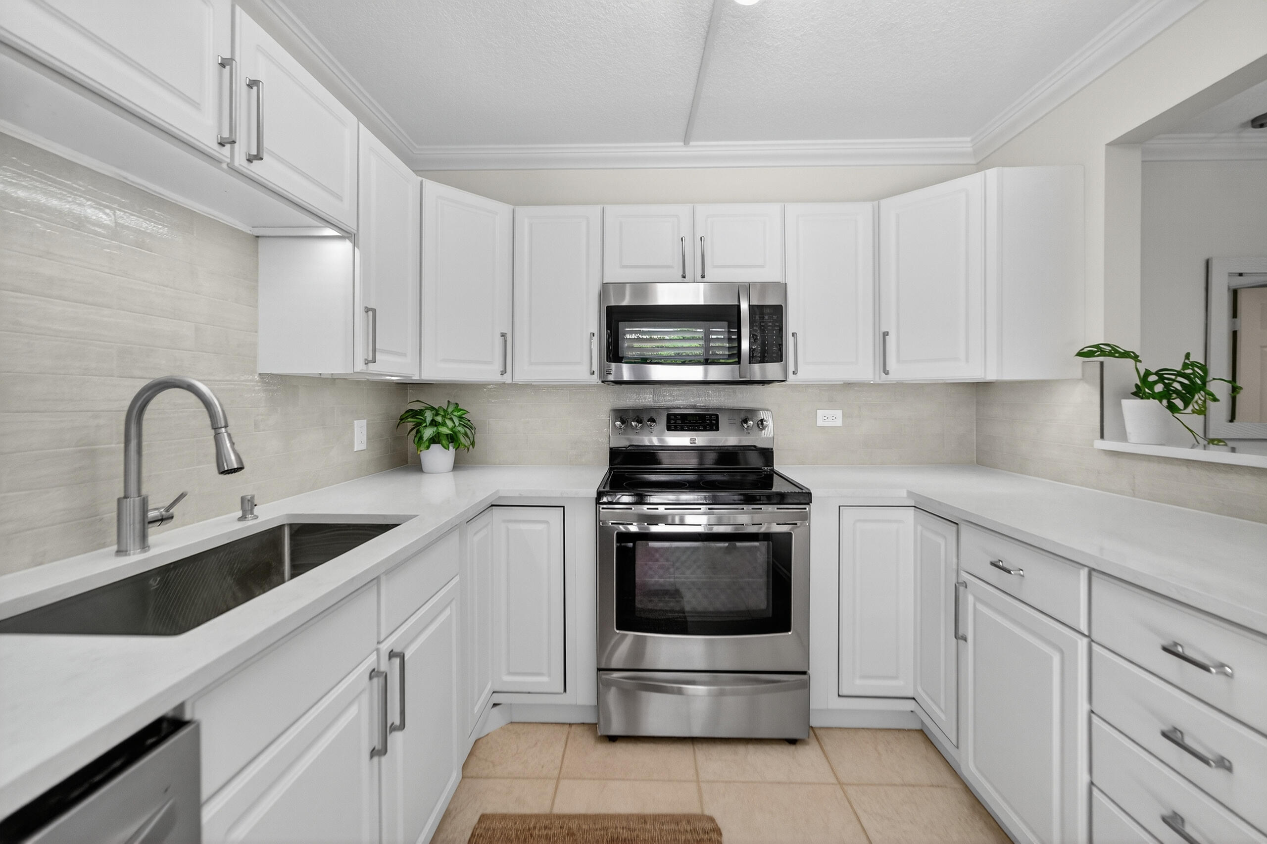 3900 County Line Road, Unit 11D Tequesta, FL 33469 - Photo 2 of 53 a kitchen with stainless steel appliances granite countertop a sink a stove a microwave and cabinets