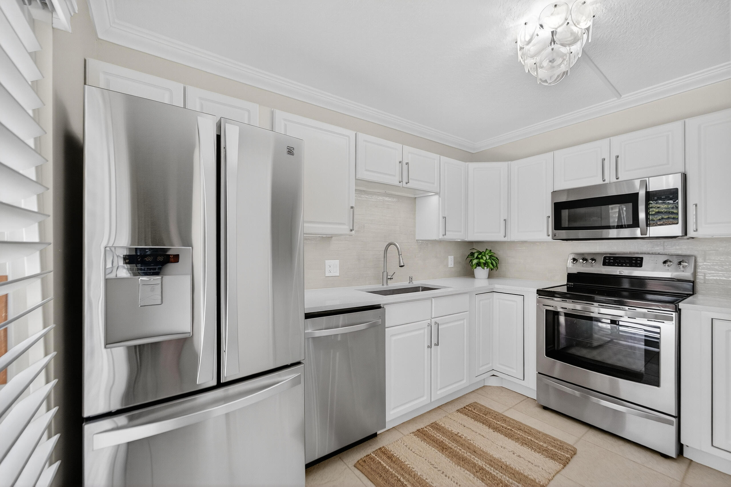 3900 County Line Road, Unit 11D Tequesta, FL 33469 - Photo 4 of 53 a kitchen with stainless steel appliances a refrigerator sink and microwave