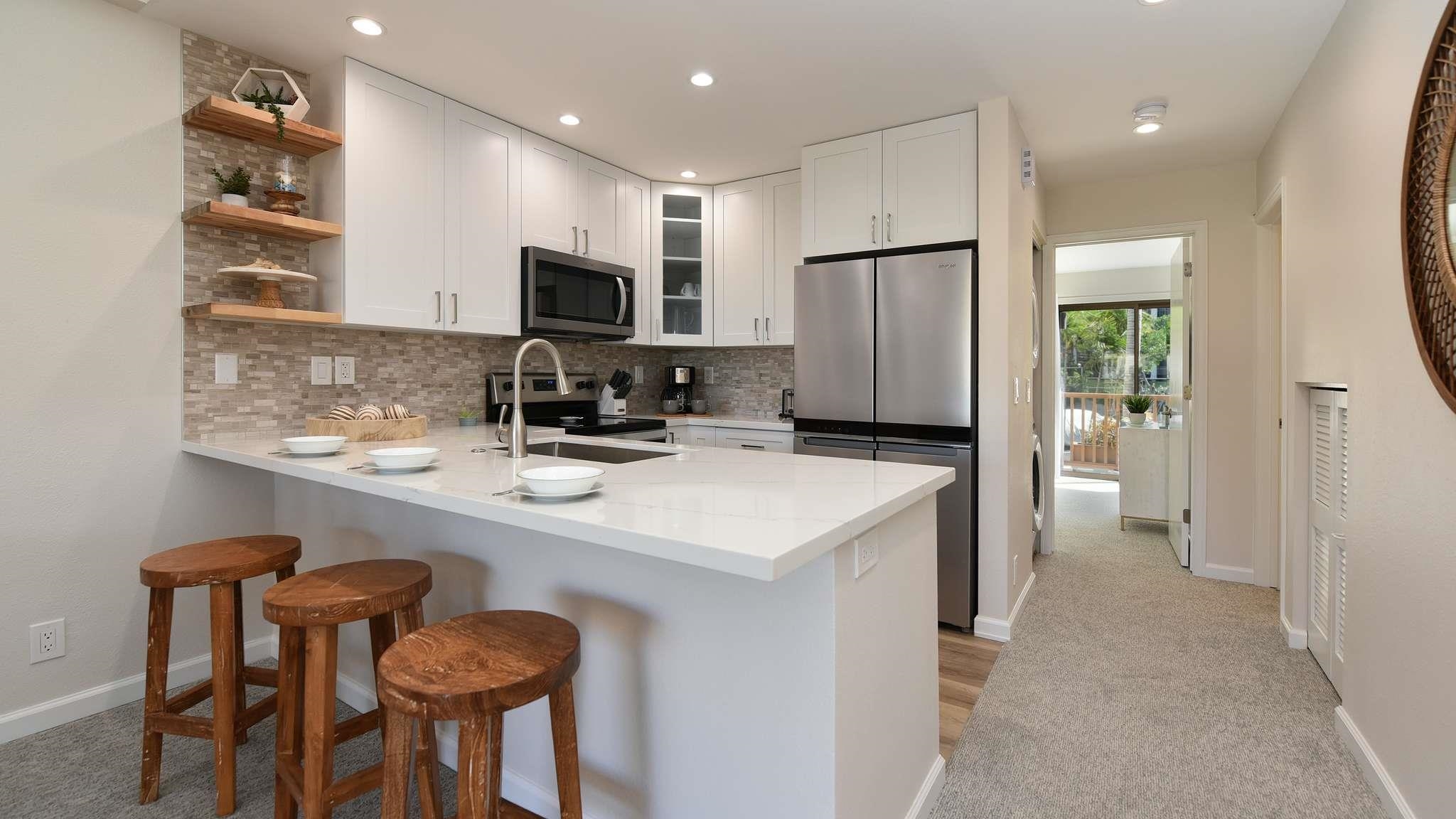 2777 South Kihei Road, Unit E202 Kihei, HI 96753 - Photo 9 of 37 a kitchen with stainless steel appliances a refrigerator and microwave