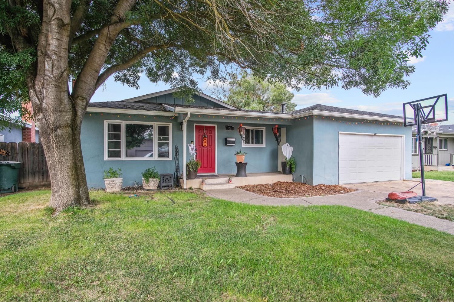 3221 Dublin Avenue Merced, CA 95340 - Photo 2 of 22 a view of a backyard with table and chairs and a large tree