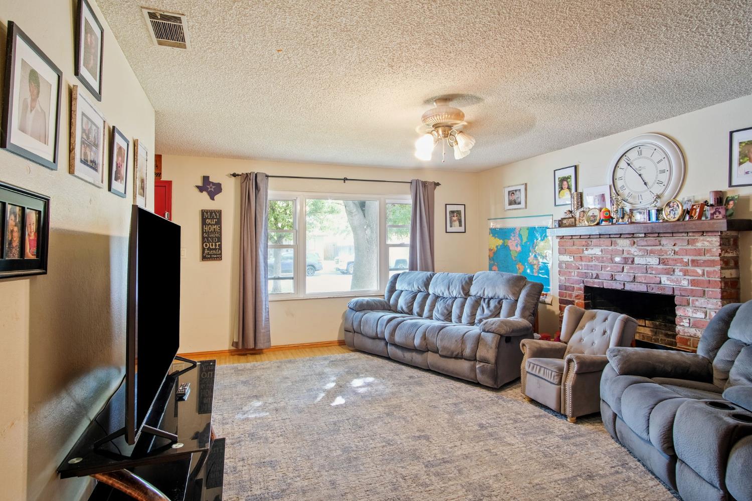 3221 Dublin Avenue Merced, CA 95340 - Photo 6 of 22 a living room with furniture a fireplace and a flat screen tv