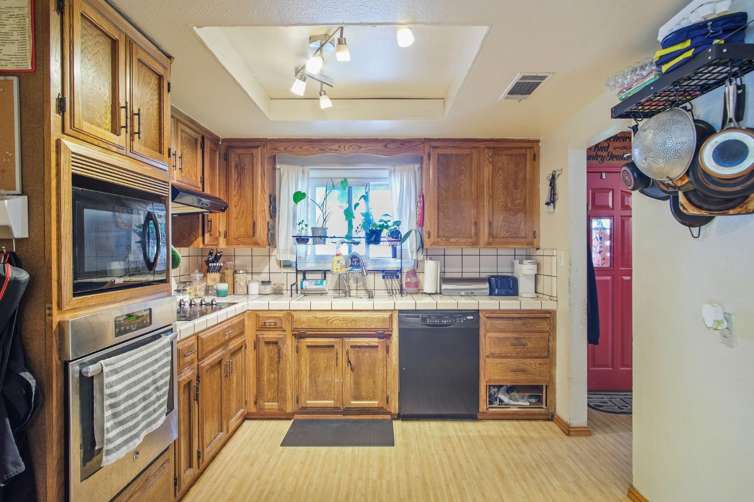 3221 Dublin Avenue Merced, CA 95340 - Photo 8 of 22 a kitchen with stainless steel appliances granite countertop a sink and wooden cabinets
