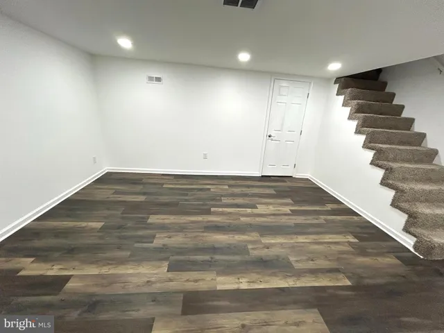 a view of an empty room with stairs and a view of hallway