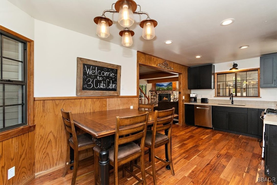 667 Talmadge Road Big Bear Lake, CA 92315 - Photo 18 of 41 a kitchen with stainless steel appliances granite countertop a stove top oven a sink a dining table and chairs with wooden floor