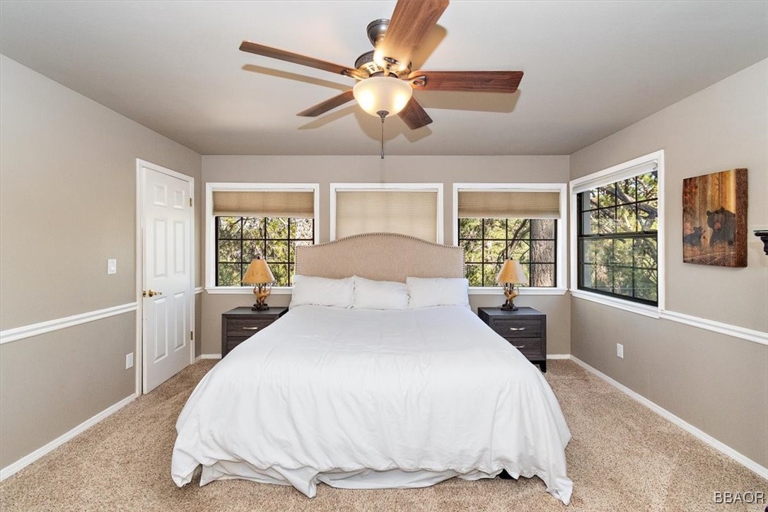 667 Talmadge Road Big Bear Lake, CA 92315 - Photo 22 of 41 a bedroom with a large bed and a chandelier