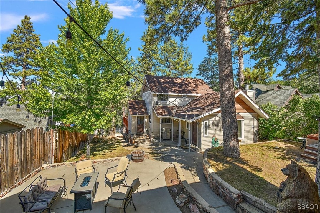 667 Talmadge Road Big Bear Lake, CA 92315 - Photo 3 of 41 a view of a patio with table and chairs with wooden fence and large trees